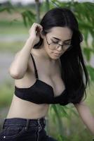 porträtt av sexig asiatisk kvinna bär svart bh på fältet, thailändska människor ta en bild foto