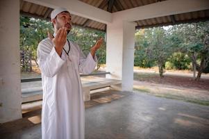 asiatisk islam man bön, ung muslim ber, ramadan festival koncept foto