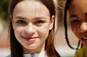 närbild ansikten av vit kaukasisk flicka och svart afrikansk amerikan tillsammans. världsenhet, raskärlek, förståelse i tolerans och samarbete mellan raser och mångfald. foto