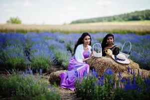 två vackra indiska tjejer bär saree Indien traditionell klänning i lila lavendelfält. foto