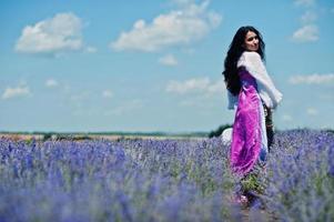 vacker indisk flicka bär saree Indien traditionell klänning i lila lavendelfält. foto