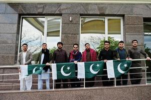 grupp av pakistanska man bär traditionella kläder salwar kameez eller kurta med pakistanska flaggor. foto