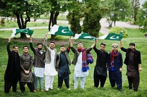 grupp av pakistanska man bär traditionella kläder salwar kameez eller kurta med pakistanska flaggor. foto