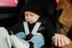 ung mor och barn i bilen. barnstol på stol. säkerhetskörningskoncept. foto