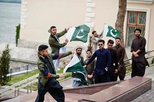 grupp av pakistanska man bär traditionella kläder salwar kameez eller kurta med pakistanska flaggor. foto