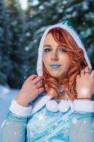 söt rödhårig kvinna i blå vinterdräkt foto
