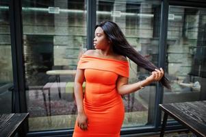 afrikansk amerikansk kvinna modell xxl i orange klänning. foto