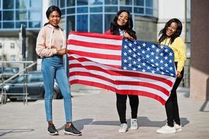 tre unga college afroamerikanska kvinnors vänner med USA:s flagga. foto