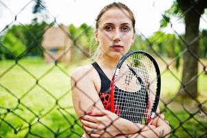 vacker sport kvinna tennisspelare med racket i sportkläder kostym. foto