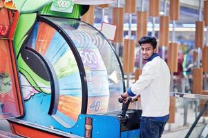 ung asiatisk man spela på lyckohjulsspelautomater för att försöka vinna på lotteri stort pris. gamble jackpot prissnurr. round drum casino pengar spel. foto