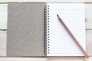 öppen anteckningsbok och penna på träbord foto