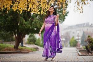 indisk hinduisk flicka på traditionell violett saree poserade på höstgatan. foto