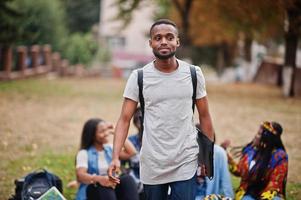 grupp på fem afrikanska högskolestudenter som spenderar tid tillsammans på campus på universitetsgården. svarta afro vänner studerar. utbildningstema. foto