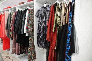 kvinnliga färgglada kläder aftonklänningar uppsättning av på ställen i klädbutik helt ny modern boutique. foto
