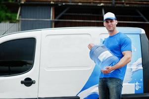 leveransmän framför lastbil som levererar flaskor med vatten. foto