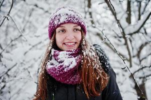 porträtt av flicka på vintern snöig dag nära snötäckta träd. foto