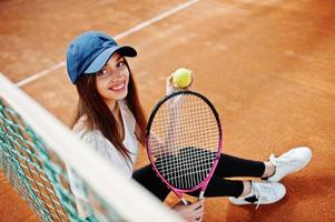 ung sportig tjejspelare med tennisracket på tennisbanan. foto