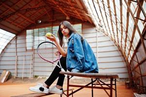 ung sportig tjejspelare med tennisracket på tennisbanan. foto