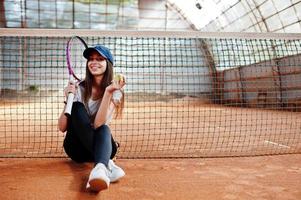 ung sportig tjejspelare med tennisracket på tennisbanan. foto