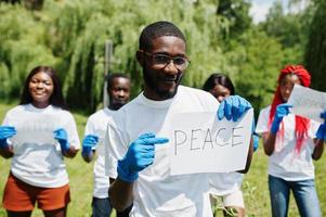 grupp glada afrikanska volontärer håller tom tavla med fredstecken i parken. Afrika volontärarbete, välgörenhet, människor och ekologi koncept. foto