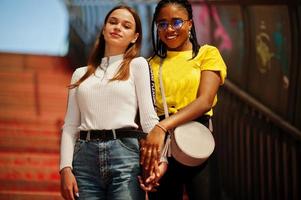 vit kaukasisk flicka och svart afroamerikan tillsammans på tonnel. världsenhet, raskärlek, förståelse i tolerans och samarbete mellan raser och mångfald. foto