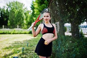 vacker sport kvinna tennisspelare med racket i sportkläder kostym. foto