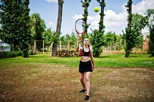 vacker sport kvinna tennisspelare med racket i sportkläder kostym. foto