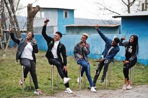 unga millennials afrikanska vänner med mobiltelefoner. glada svarta människor som har roligt tillsammans. generation z vänskap koncept. foto
