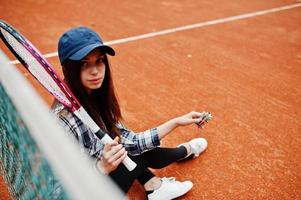 ung sportig tjejspelare med tennisracket på tennisbanan. foto