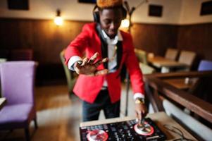 mode afrikansk amerikansk man modell dj i röd kostym med dj controller. foto