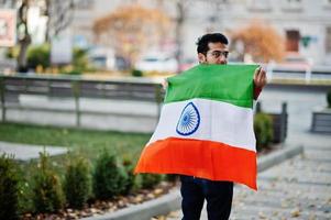 sydasiatisk indisk manlig student med Indien flagga poserade utomhus. foto