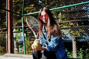 ung sportig tjejspelare med tennisracket på tennisbanan. foto