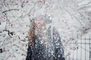 porträtt av flicka på vintern snöig dag nära snötäckta träd. foto