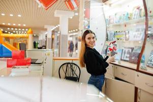 porträtt av ung kaukasisk kvinnlig kvinna säljare. småföretag av godis souvenirbutik. foto