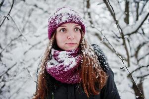 porträtt av flicka på vintern snöig dag nära snötäckta träd. foto