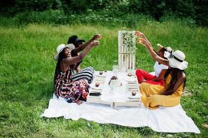 grupp afroamerikanska flickor som firar födelsedagsfest och klirrande glasögon utomhus med inredning. foto
