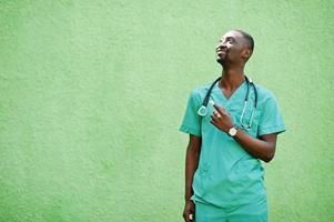 porträtt av afrikansk manlig läkare med stetoskop klädd i grön rock. foto