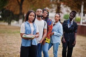 rad av grupp fem afrikanska högskolestudenter tillbringar tid tillsammans på campus på universitetsgården. svarta afro vänner studerar. utbildningstema. foto