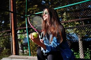 ung sportig tjejspelare med tennisracket på tennisbanan. foto