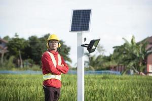 man under installationen av solcellspaneler i jordbruksområden foto