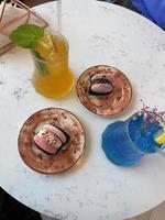 ett bord på ett café med lemonad och makroner foto