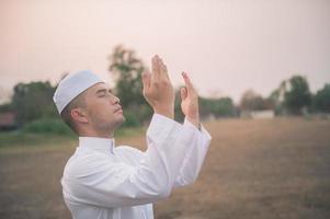 asiatisk islam man bön, ung muslim ber, ramadan festival koncept foto