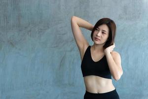 närbild asiatisk vacker sport flicka på väggen av gym, thailand älskar hälsa, smal kvinna träningskoncept foto