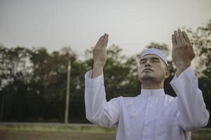 asiatisk islam man bön, ung muslim ber, ramadan festival koncept foto