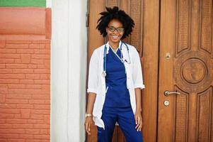 porträtt av afrikansk amerikansk kvinnlig läkare med stetoskop klädd i labbrock. foto