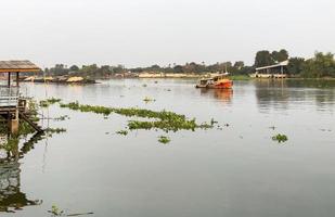 en bogserbåt bogserar den stora lastbåten full med sand i den stora floden. foto