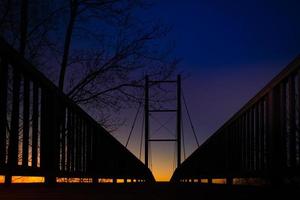 låg vinkel vy av en silhuett bro vid solnedgången foto