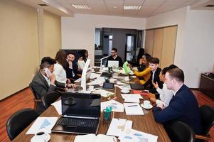 multiracial unga kreativa människor i moderna kontor. grupp unga affärsmän arbetar tillsammans med laptop, surfplatta. framgångsrikt frilansarteam inom coworking. foto