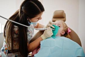 liten flicka på tandläkare stol. barn tandläkare. foto