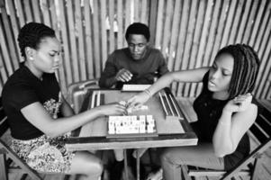 grupp på tre afroamerikanska vänner spelar bordsspel. foto